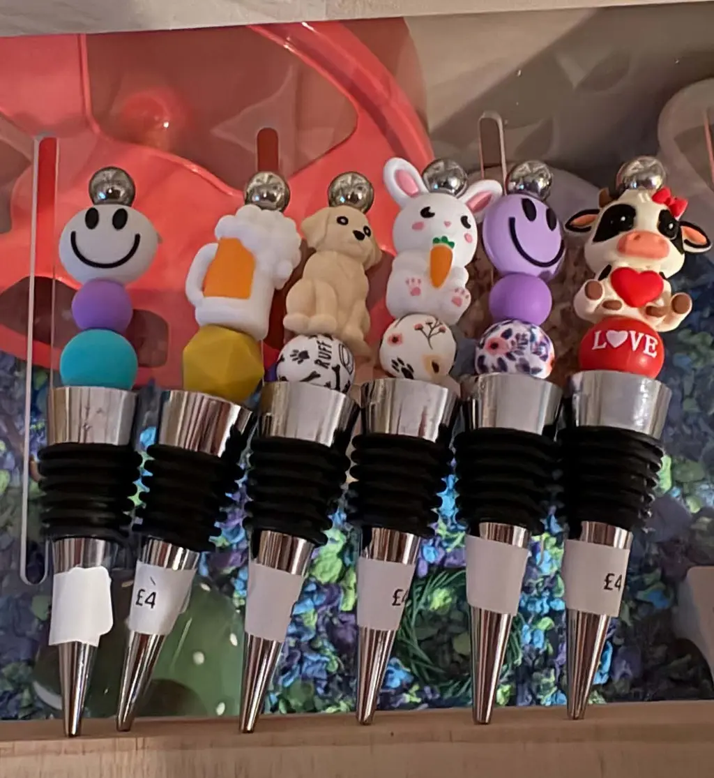 Six bottle stoppers topped with smiley, beer mug, puppy, bunny and cow charms