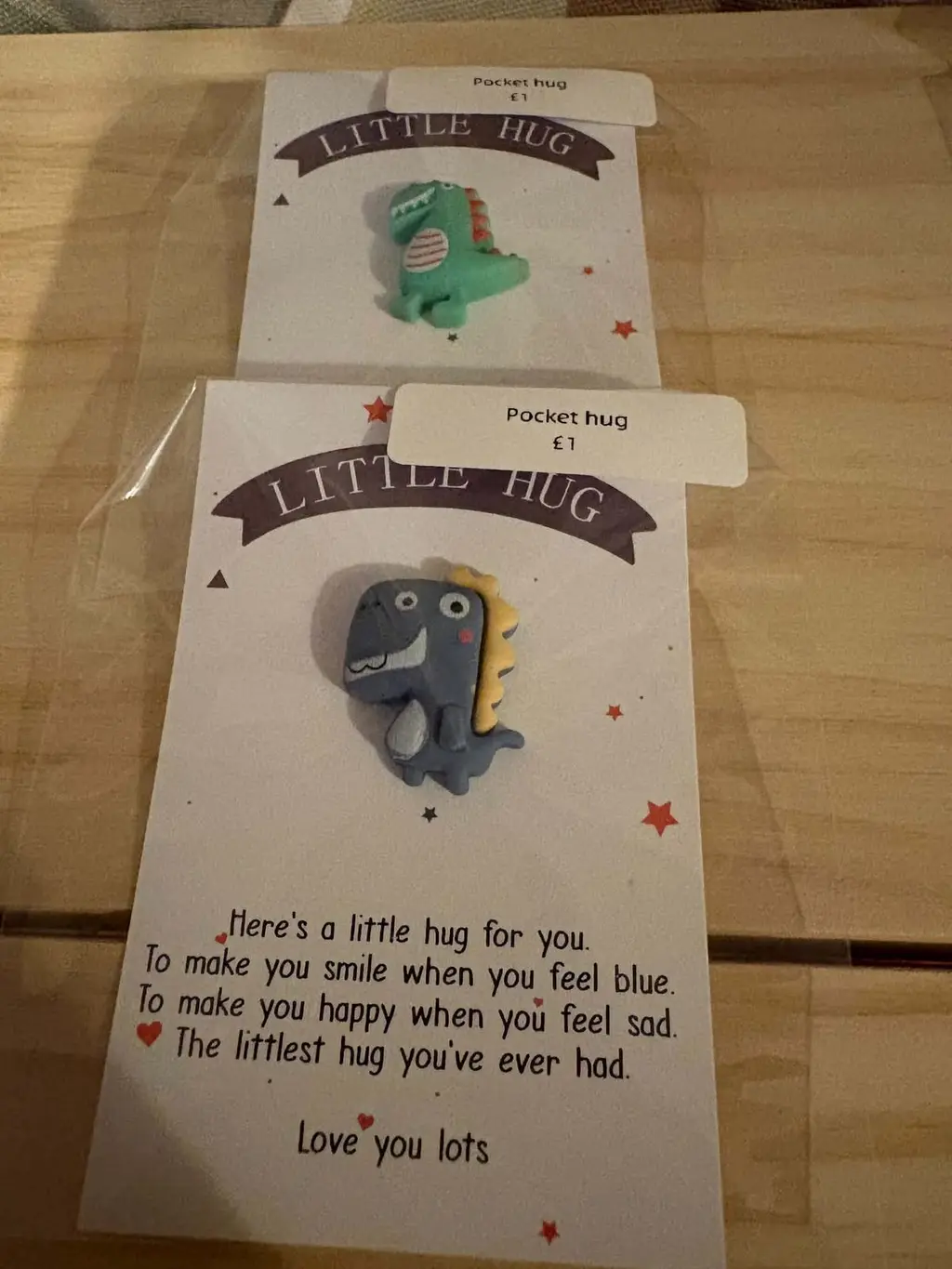 Two Little Hug cards, one with a blue dinosaur charm and one with a green dinosaur charm